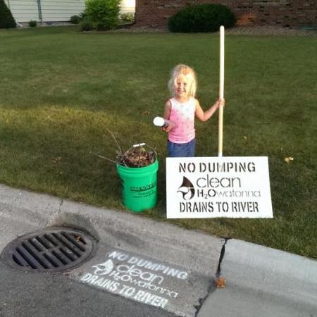 Small child by a sign that says No Dumping