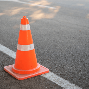 Orange traffic cone on asphalt roadway 